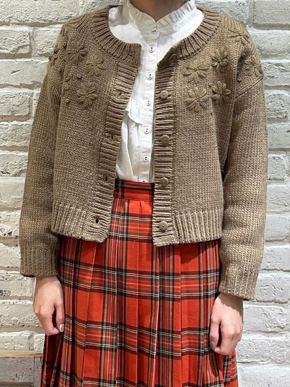 ホワイト系のシャツ/ブラウス、ブラウン系のカーディガン/ボレロ、レッド系のスカートを着用したレディースの冬コーディネートの2枚目の写真