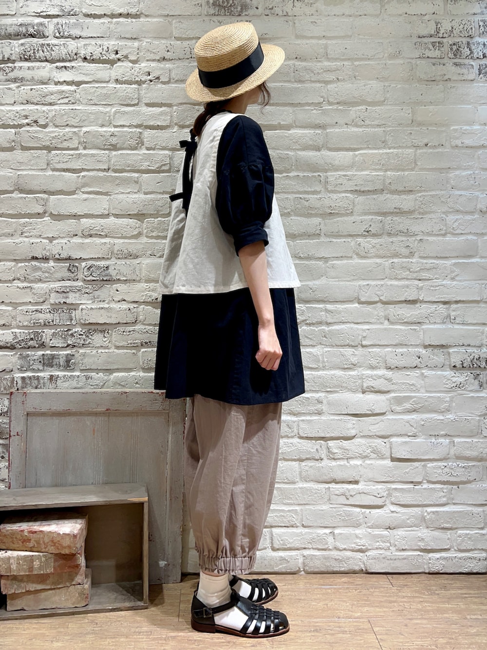 ホワイト系のベスト、ブラック系のチュニック、ブラウン系のその他パンツを着用したレディースの夏コーディネートの3枚目の写真