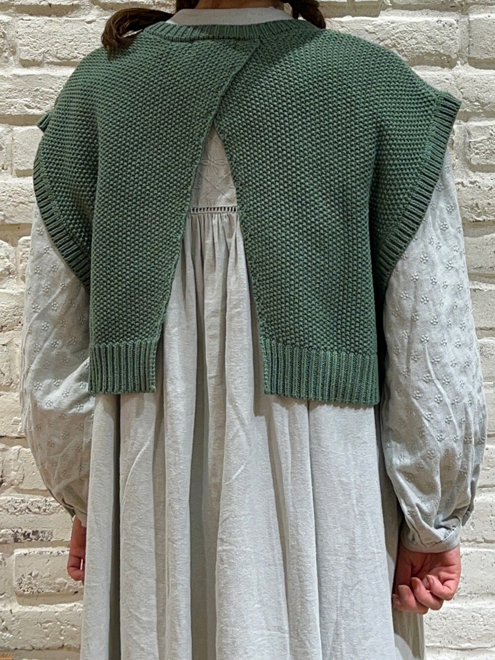 ホワイト系のシャツ/ブラウス、グリーン系のベスト、グリーン系のワンピースを着用したレディースの冬コーディネートの3枚目の写真