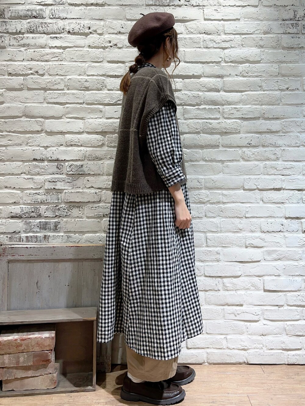 ブラウン系のベスト、ブラック系のワンピース、ベージュ系のその他パンツを着用したレディースの秋コーディネートの3枚目の写真