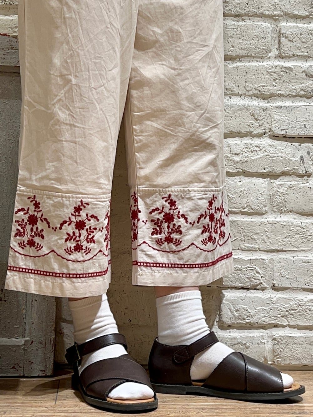 ベージュ系のタンクトップ、ブラウン系のカーディガン/ボレロ、ブラック系のハンドバッグを着用したレディースの春コーディネートの5枚目の写真