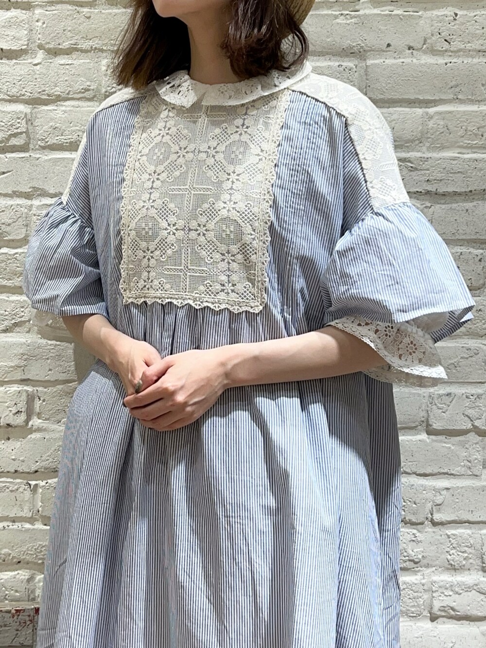 ホワイト系のシャツ/ブラウス、ブルー系のワンピース、ベージュ系のハンドバッグを着用したレディースの春コーディネートの2枚目の写真