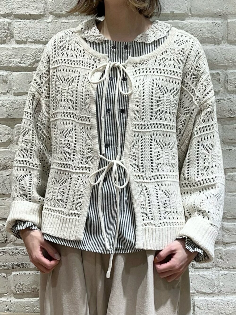 グレー系のシャツ/ブラウス、ホワイト系のニット/セーター、ベージュ系のその他パンツを着用したレディースの冬コーディネートの2枚目の写真