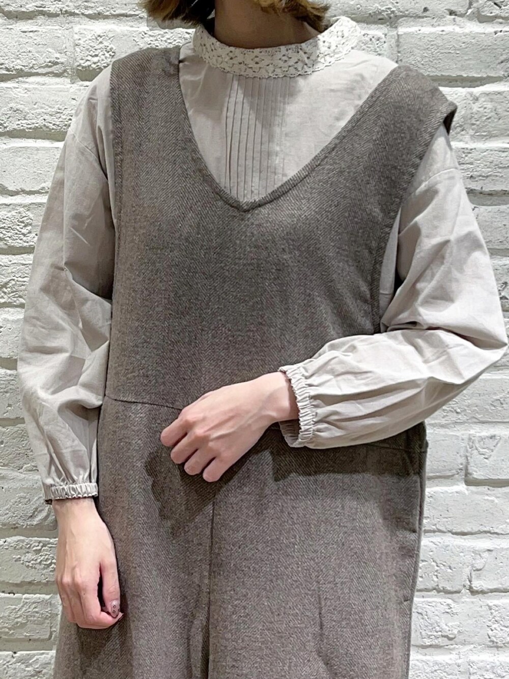 ベージュ系のシャツ/ブラウス、グレー系のカーディガン/ボレロ、ブラウン系のサロペット/オーバーオールを着用したレディースの秋コーディネートの3枚目の写真