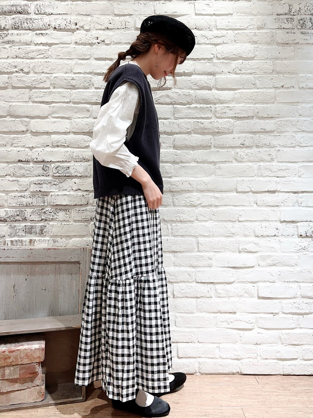 ブルー系のベスト、ホワイト系のシャツ/ブラウス、ブラック系のスカートを着用したレディースの春コーディネートの3枚目の写真