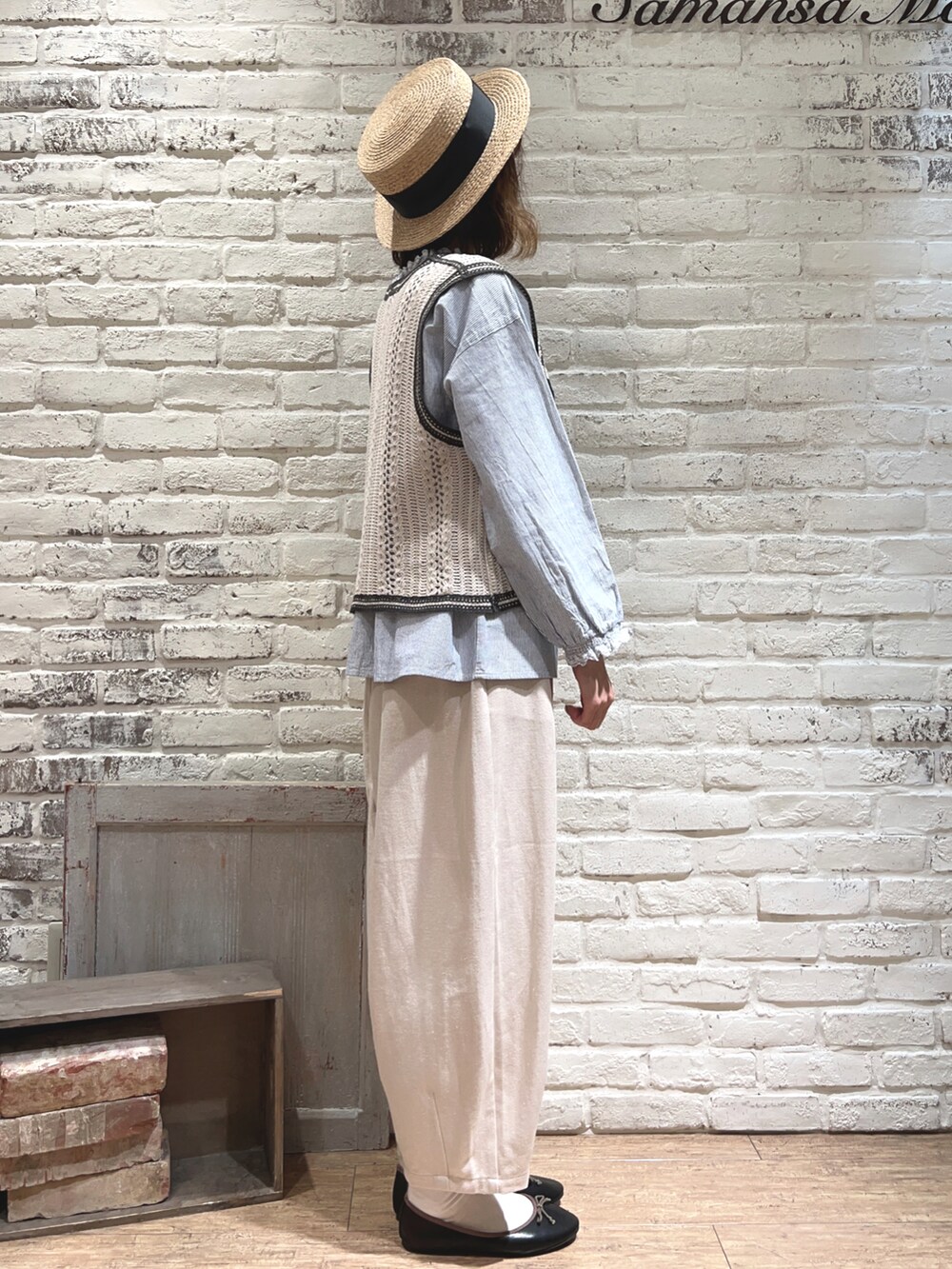 ブルー系のシャツ/ブラウス、ホワイト系のベスト、ブラック系のハンドバッグを着用したレディースの春コーディネートの3枚目の写真