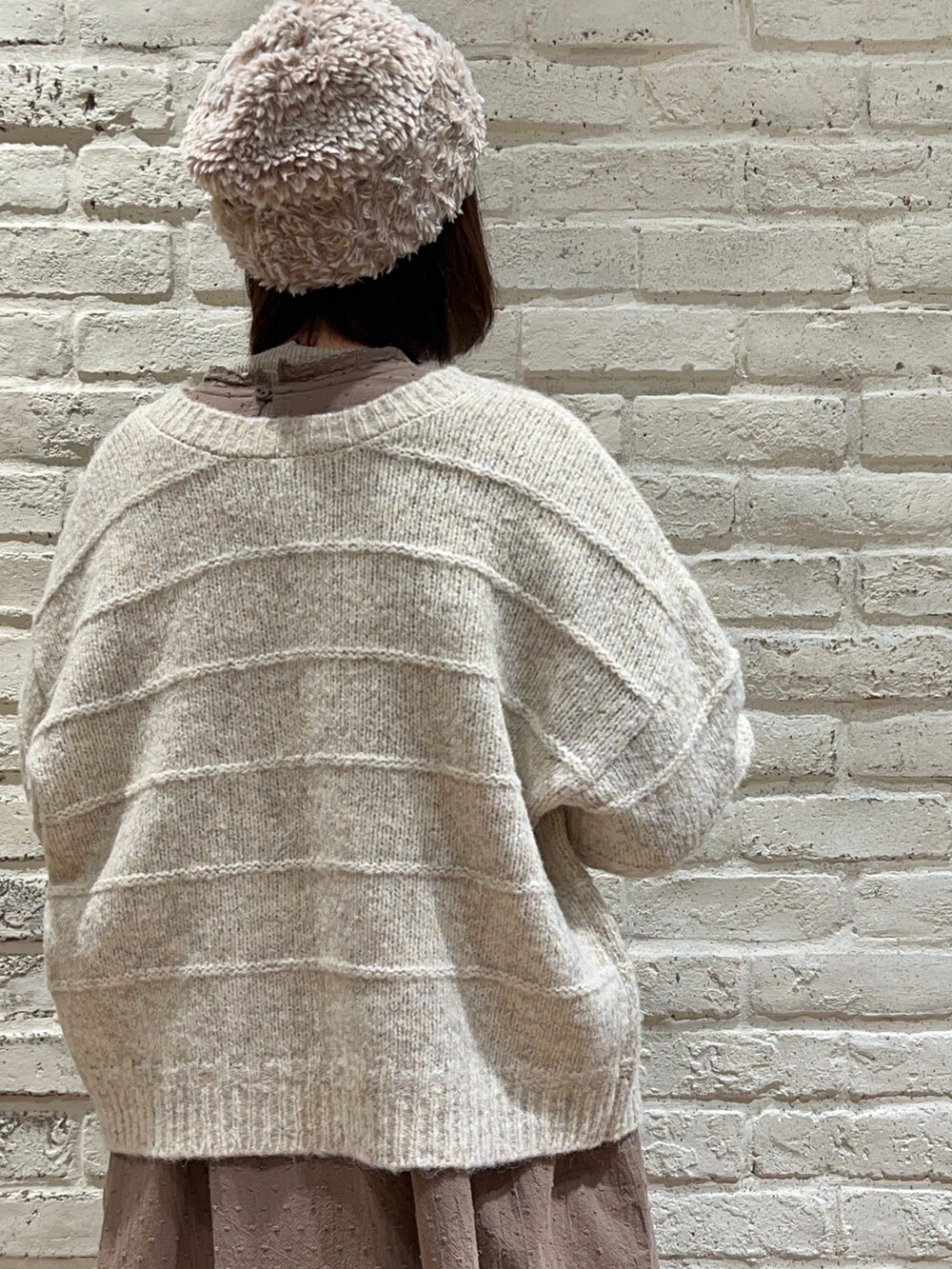 ホワイト系のカーディガン/ボレロ、ブラウン系のワンピース、ベージュ系のカーゴパンツを着用したレディースの冬コーディネートの5枚目の写真