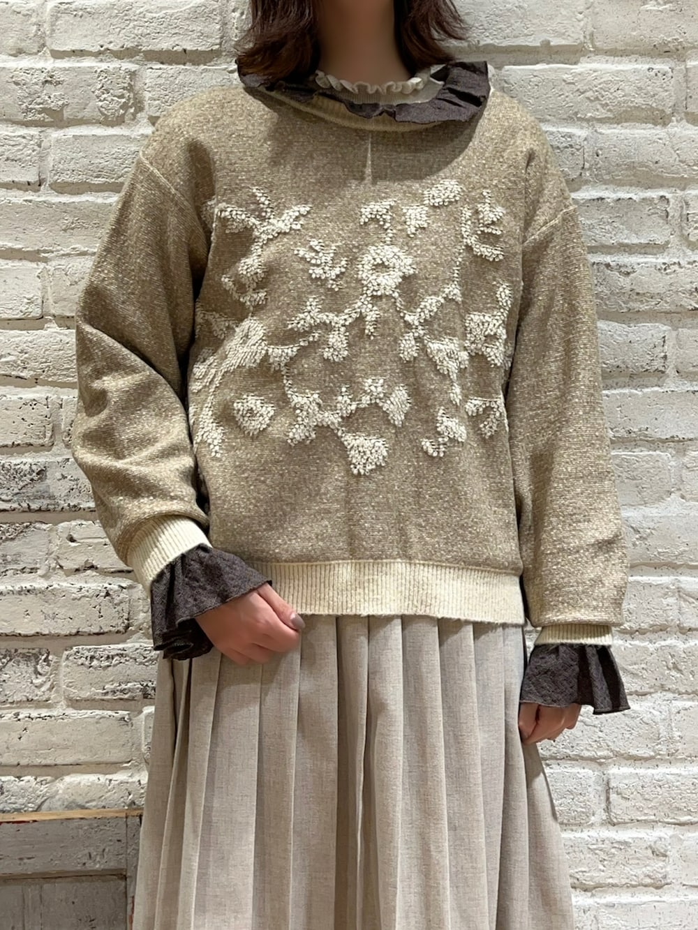 ホワイト系のニット/セーター、ベージュ系のカーディガン/ボレロ、グレー系のシャツ/ブラウスを着用したレディースの冬コーディネートの2枚目の写真