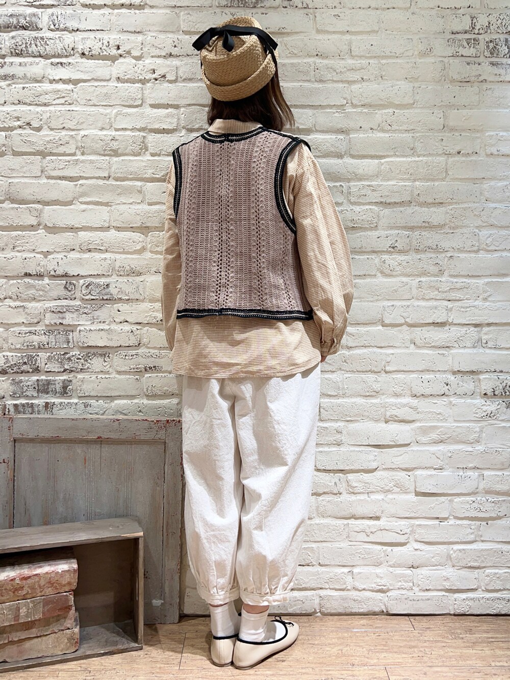 ベージュ系のシャツ/ブラウス、ベージュ系のベスト、ホワイト系のハンドバッグを着用したレディースの春コーディネートの4枚目の写真