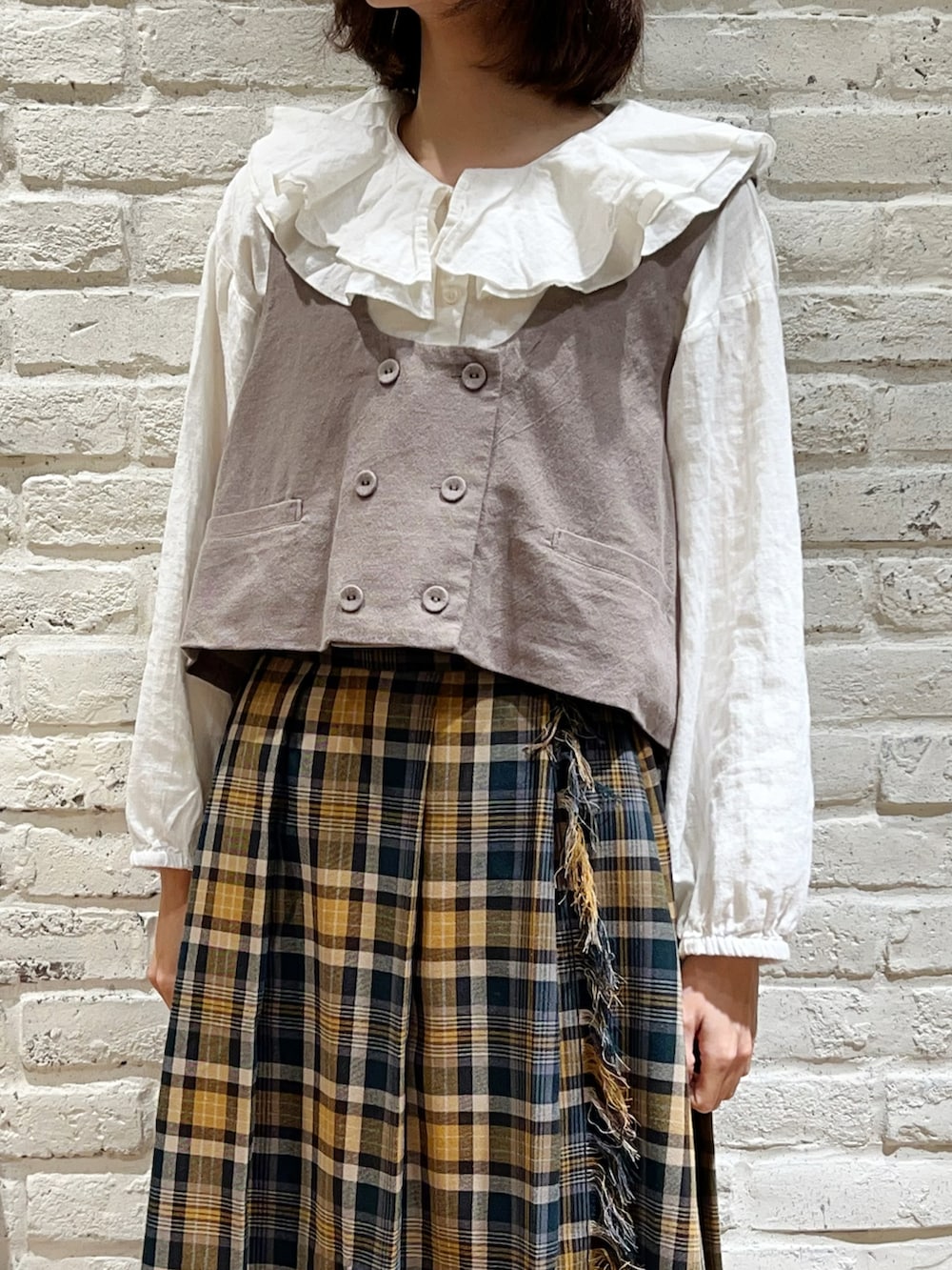 ホワイト系のシャツ/ブラウス、ブラウン系のベスト、グリーン系のスカートを着用したレディースの冬コーディネートの2枚目の写真