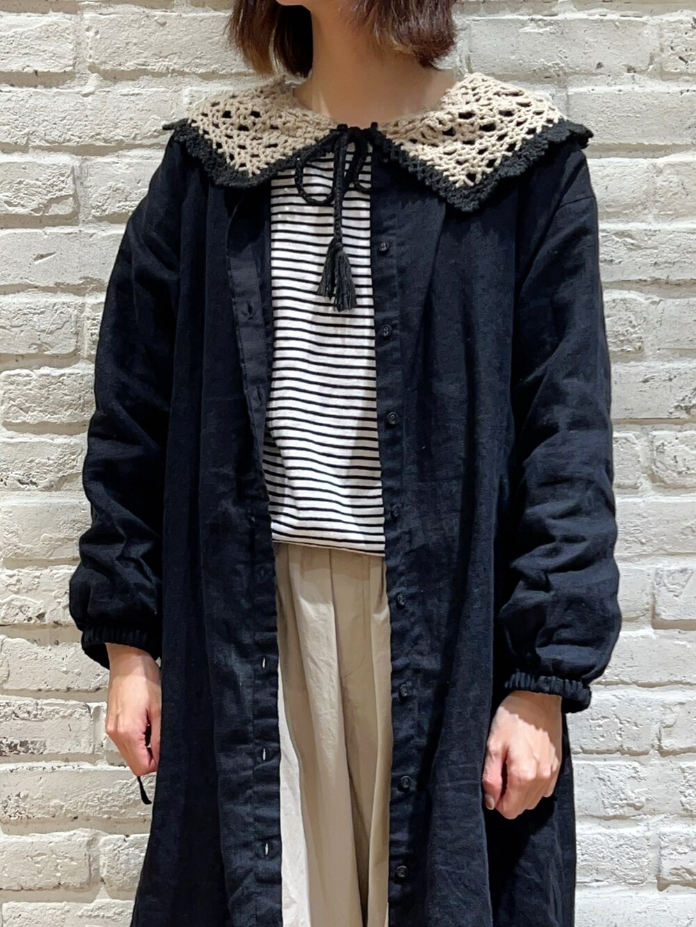 グレー系のTシャツ/カットソー、ブラック系のワンピース、ベージュ系のカーゴパンツを着用したレディースの冬コーディネートの2枚目の写真