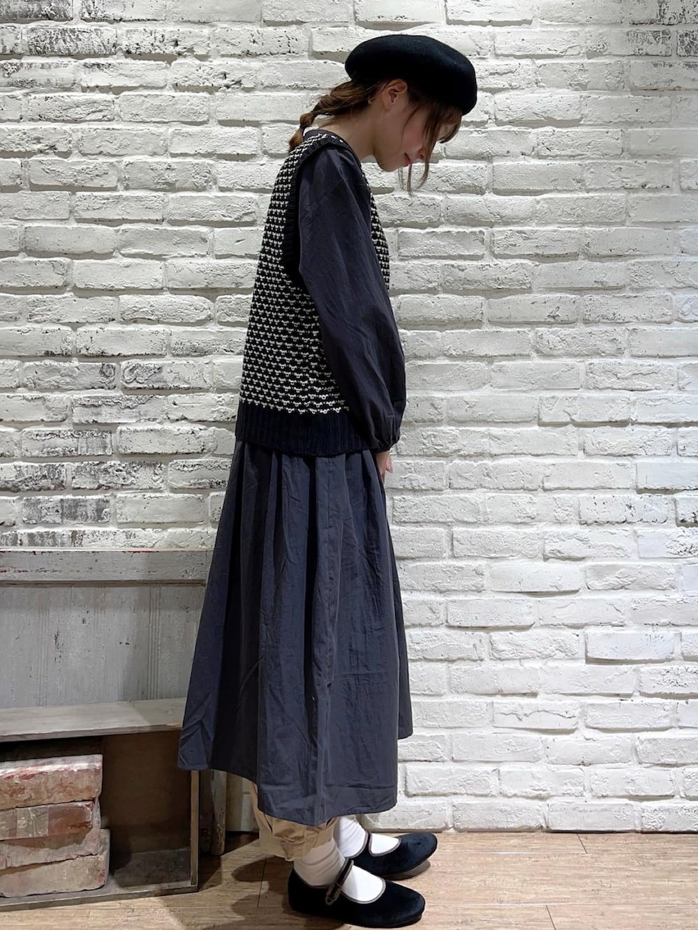 ブラック系のベスト、グレー系のワンピース、ベージュ系のその他パンツを着用したレディースの秋コーディネートの3枚目の写真