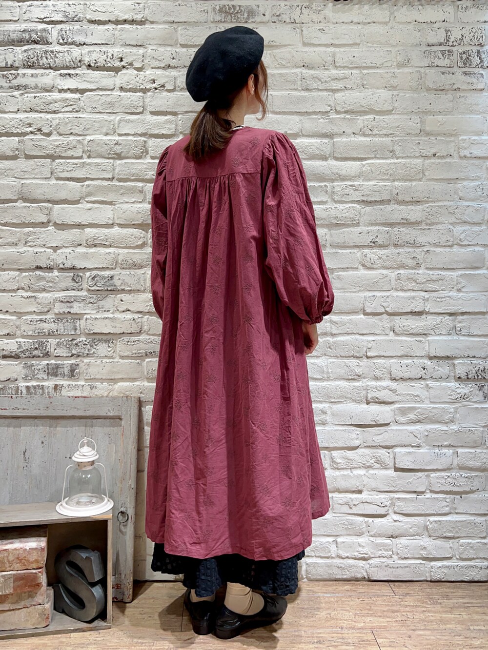 ホワイト系のTシャツ/カットソー、レッド系のワンピース、ブラック系のスカートを着用したレディースの秋コーディネートの4枚目の写真