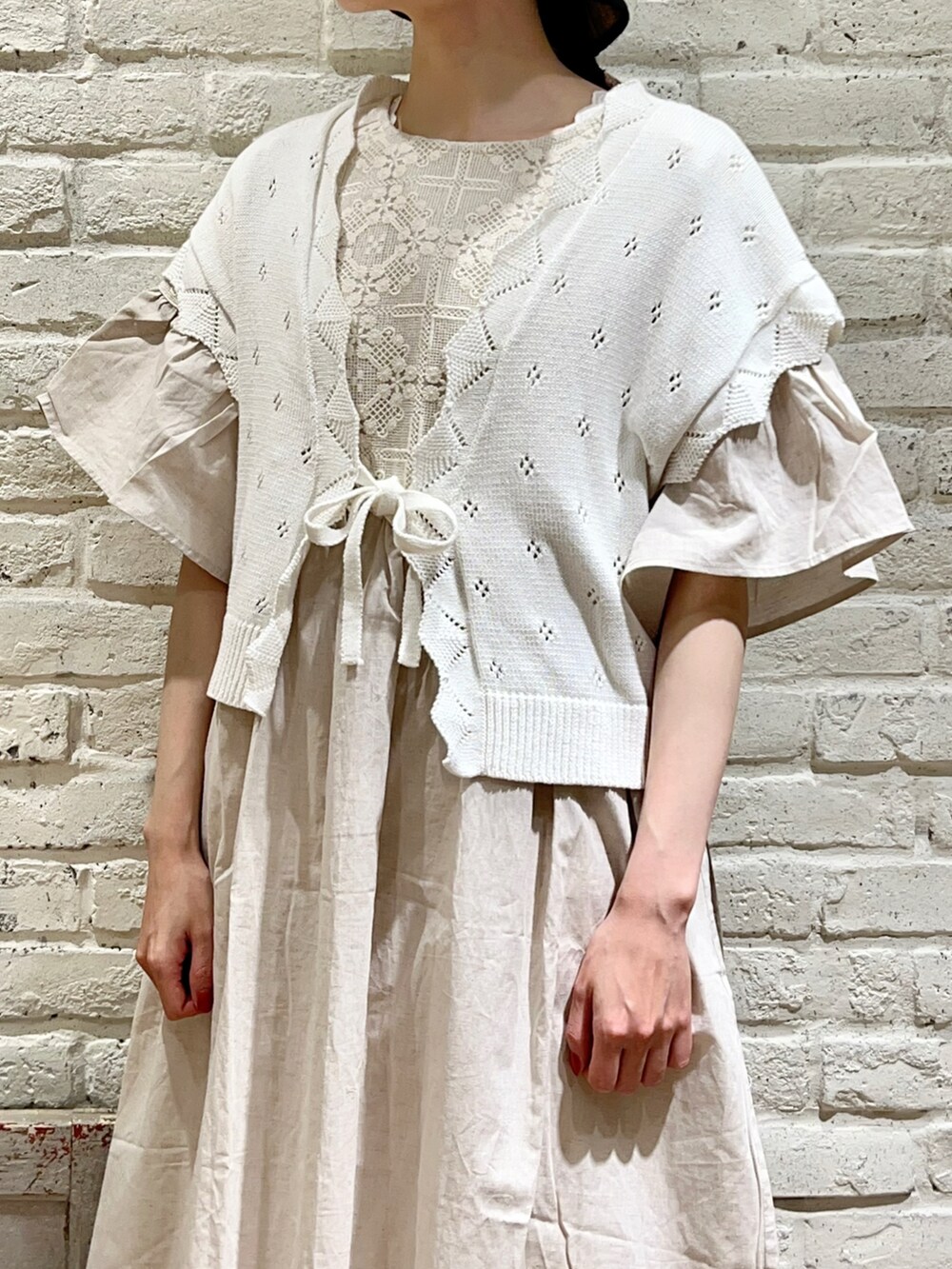 ホワイト系のタンクトップ、ホワイト系のベスト、ホワイト系のワンピースを着用したレディースの夏コーディネートの2枚目の写真