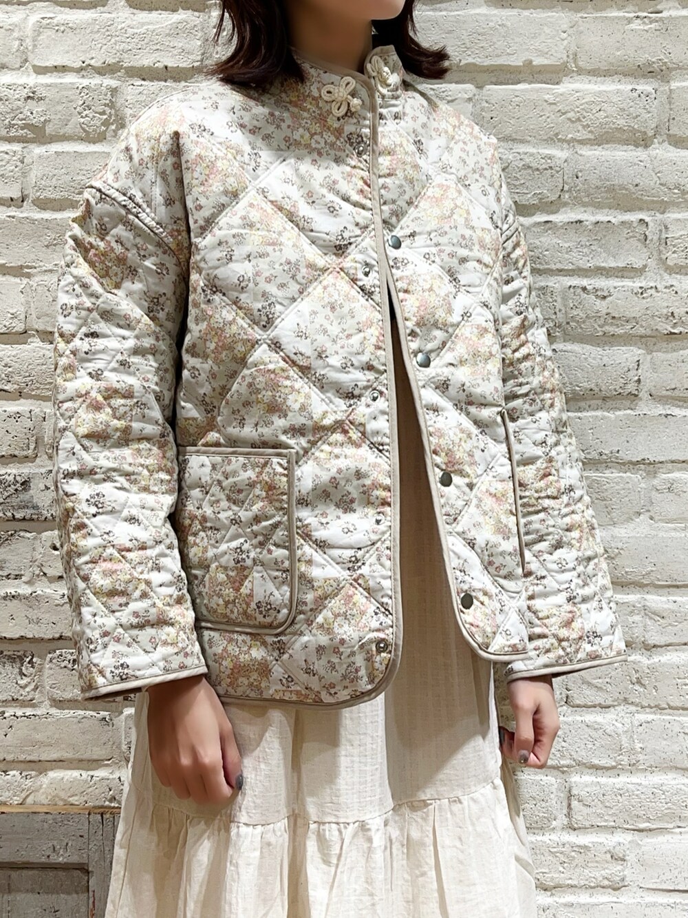 ホワイト系のニット/セーター、ベージュ系のノーカラージャケット、ホワイト系のワンピースを着用したレディースの冬コーディネートの2枚目の写真