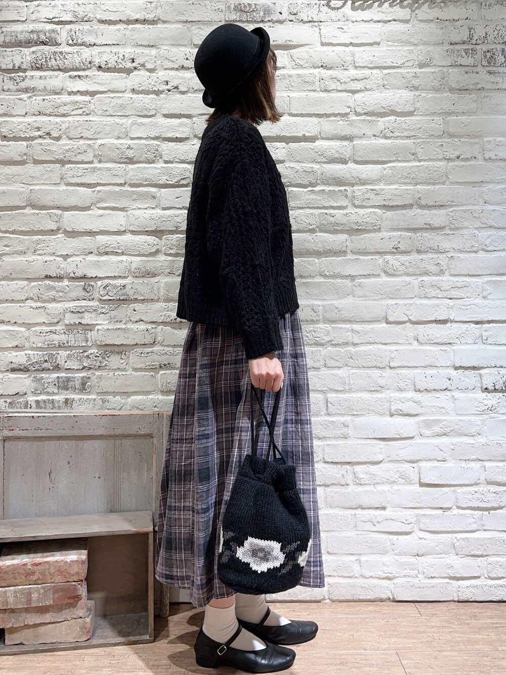 ブラック系のシャツ/ブラウス、ブラック系のニット/セーター、ブラック系のスカートを着用したレディースの冬コーディネートの3枚目の写真