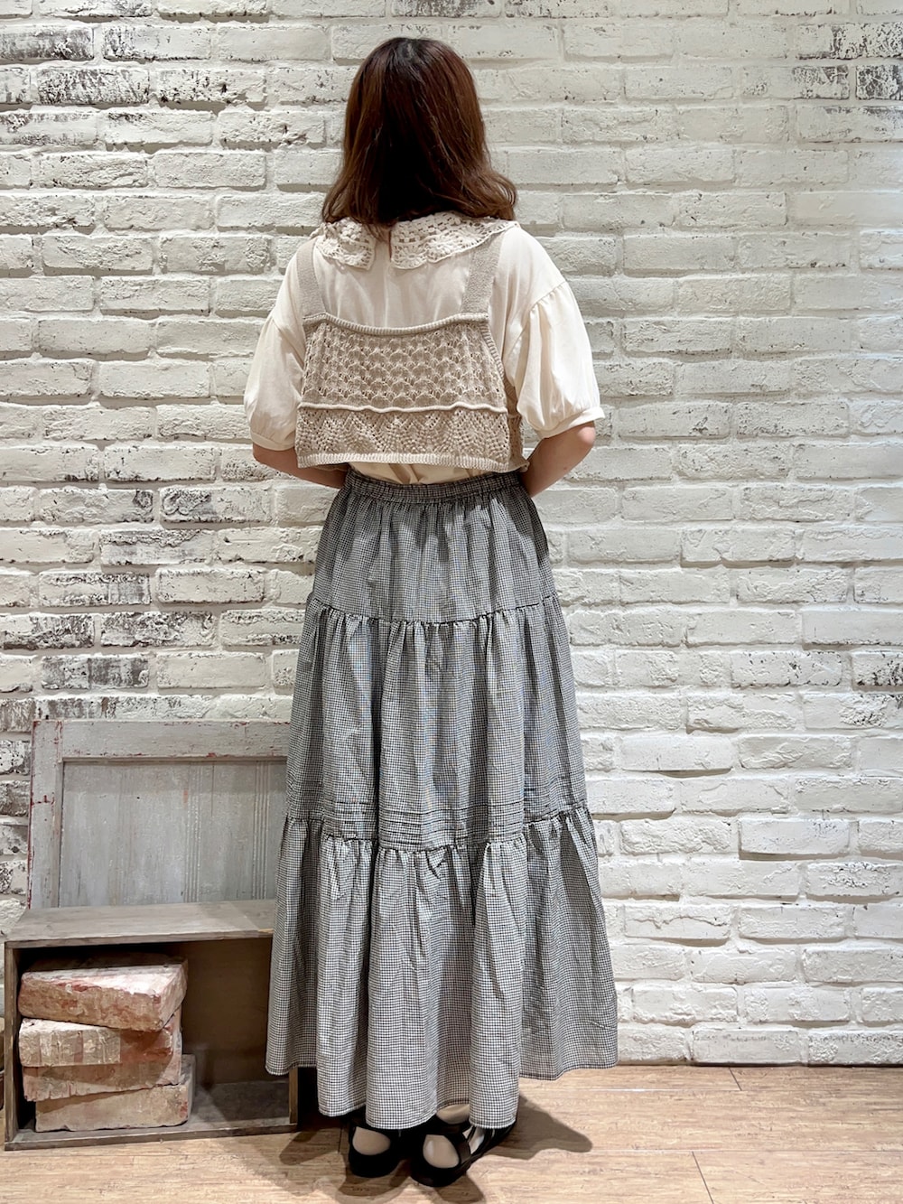 ホワイト系のTシャツ/カットソー、ベージュ系のベスト、ベージュ系のハンドバッグを着用したレディースの秋コーディネートの4枚目の写真
