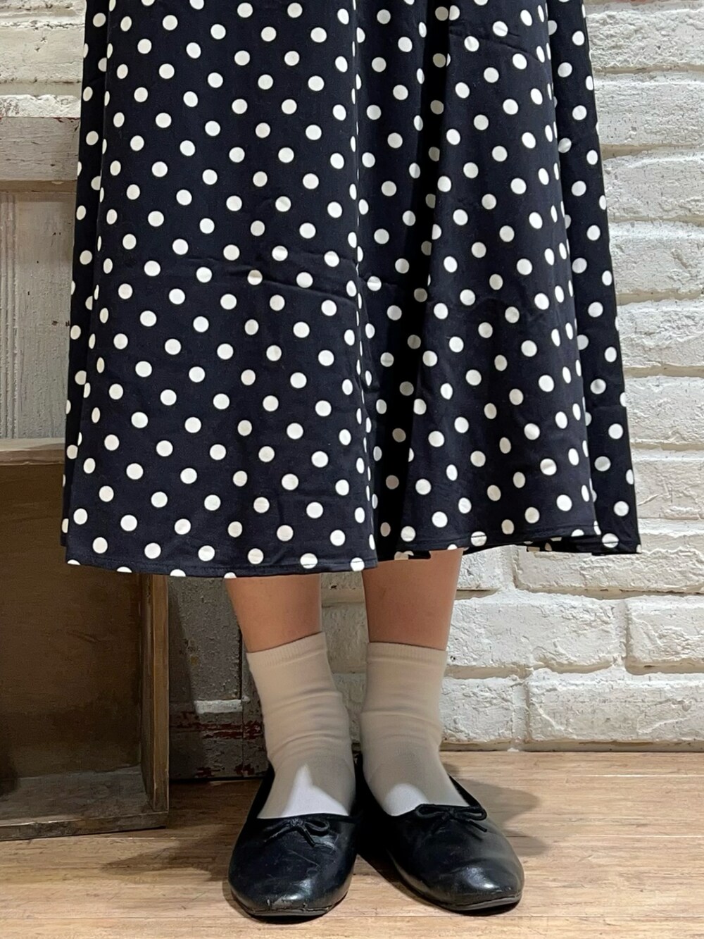 ベージュ系のニット/セーター、ホワイト系のシャツ/ブラウス、ブラック系のスカートを着用したレディースの冬コーディネートの5枚目の写真