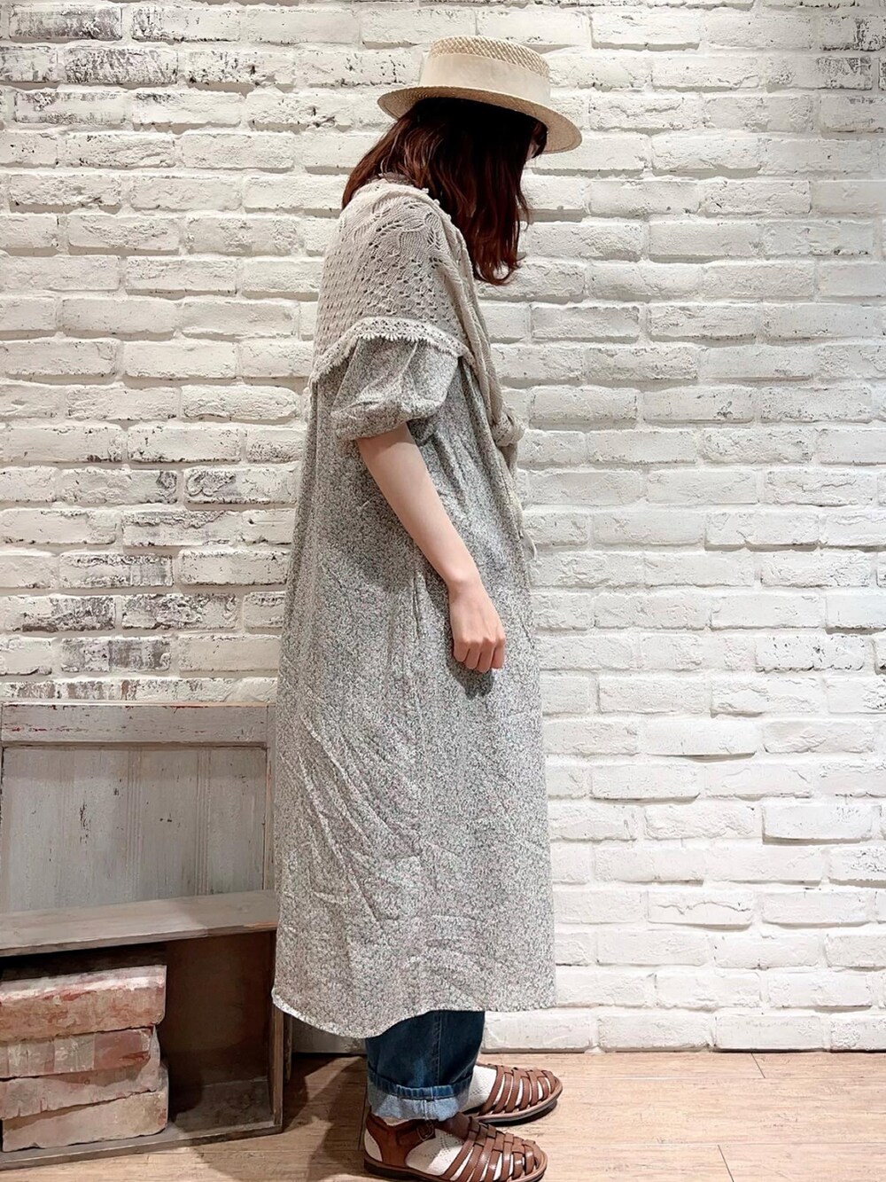 グリーン系のワンピース、ブルー系のデニムパンツ、イエロー系のサンダルを着用したレディースの春コーディネートの3枚目の写真