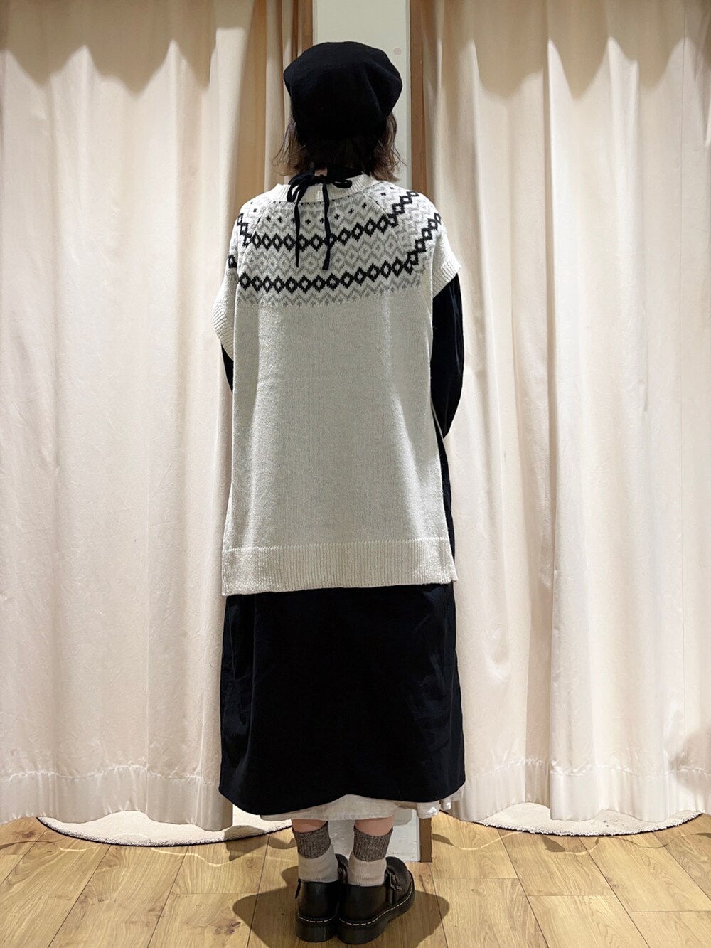 ホワイト系のTシャツ/カットソー、ホワイト系のベスト、ブラック系のワンピースを着用したレディースの冬コーディネートの4枚目の写真