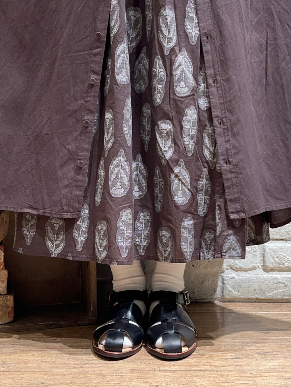 グレー系のワンピース、ブラウン系のスカート、ブラック系のサンダルを着用したレディースの春コーディネートの5枚目の写真