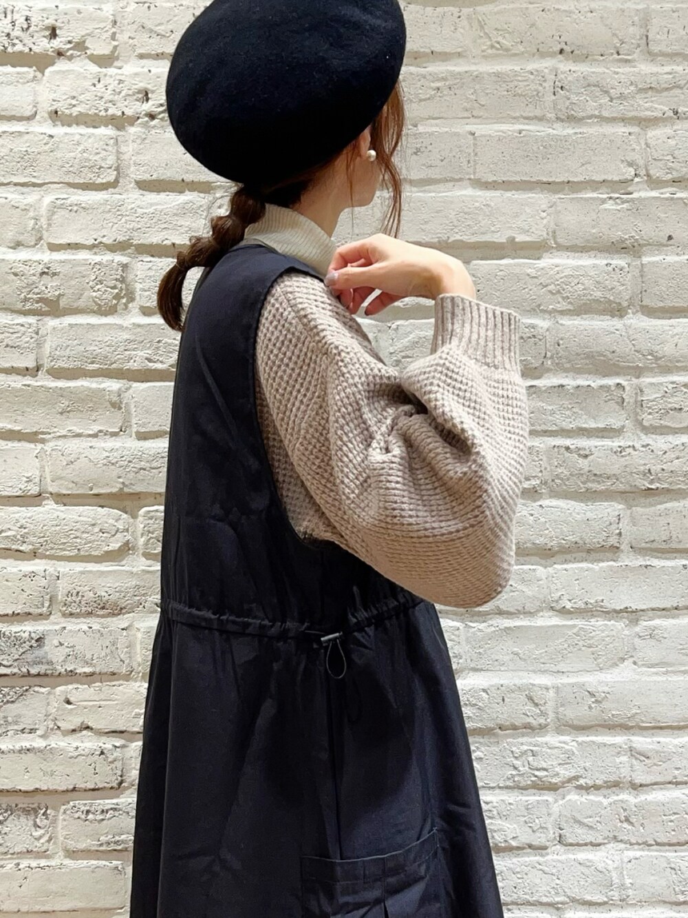 ホワイト系のニット/セーター、ブラック系のワンピース、ブラック系のブーツを着用したレディースの冬コーディネートの3枚目の写真