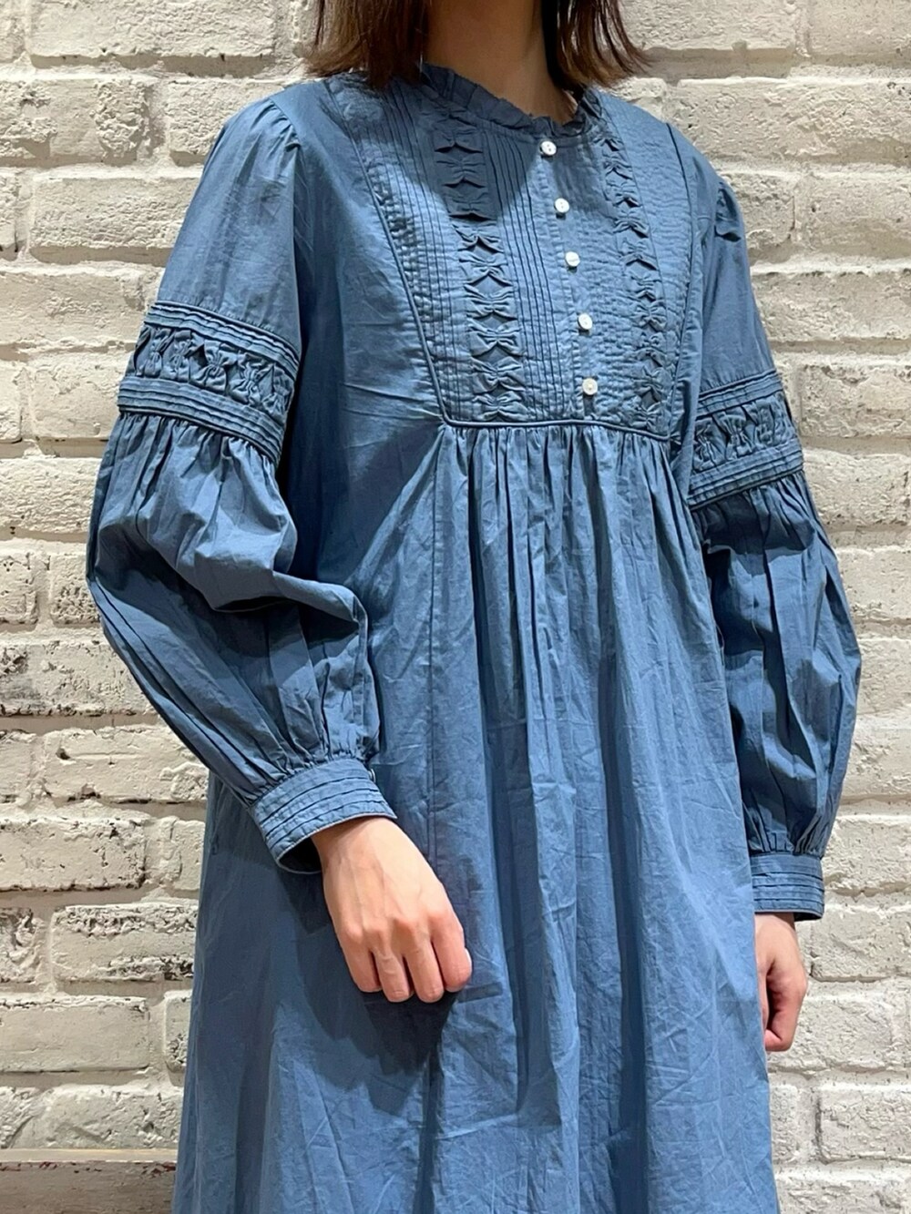 ブルー系のワンピース、ホワイト系のスカート、ブラック系のサンダルを着用したレディースの春コーディネートの2枚目の写真