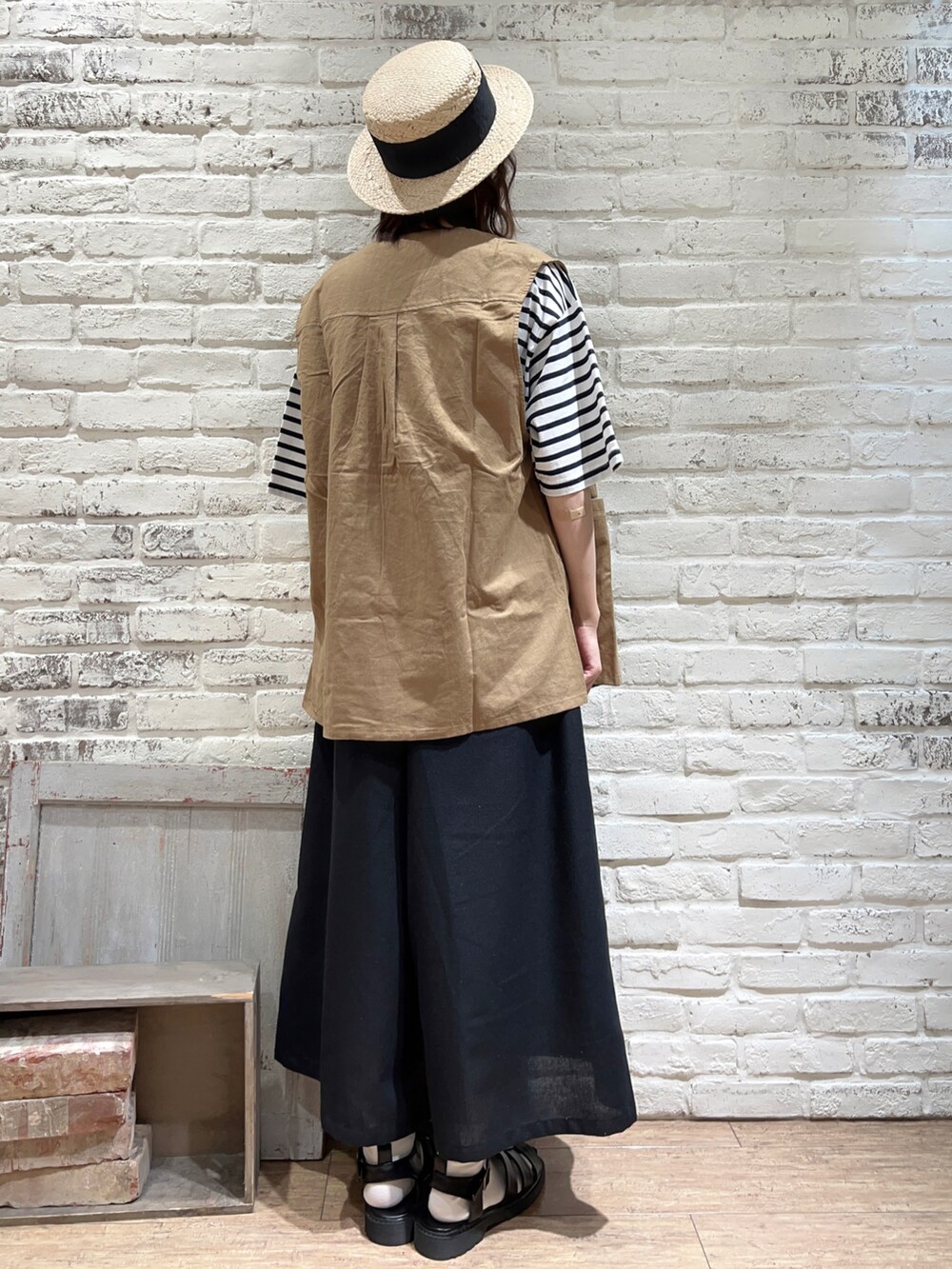 ホワイト系のTシャツ/カットソー、ベージュ系のベスト、ブラック系のハンドバッグを着用したレディースの春コーディネートの4枚目の写真