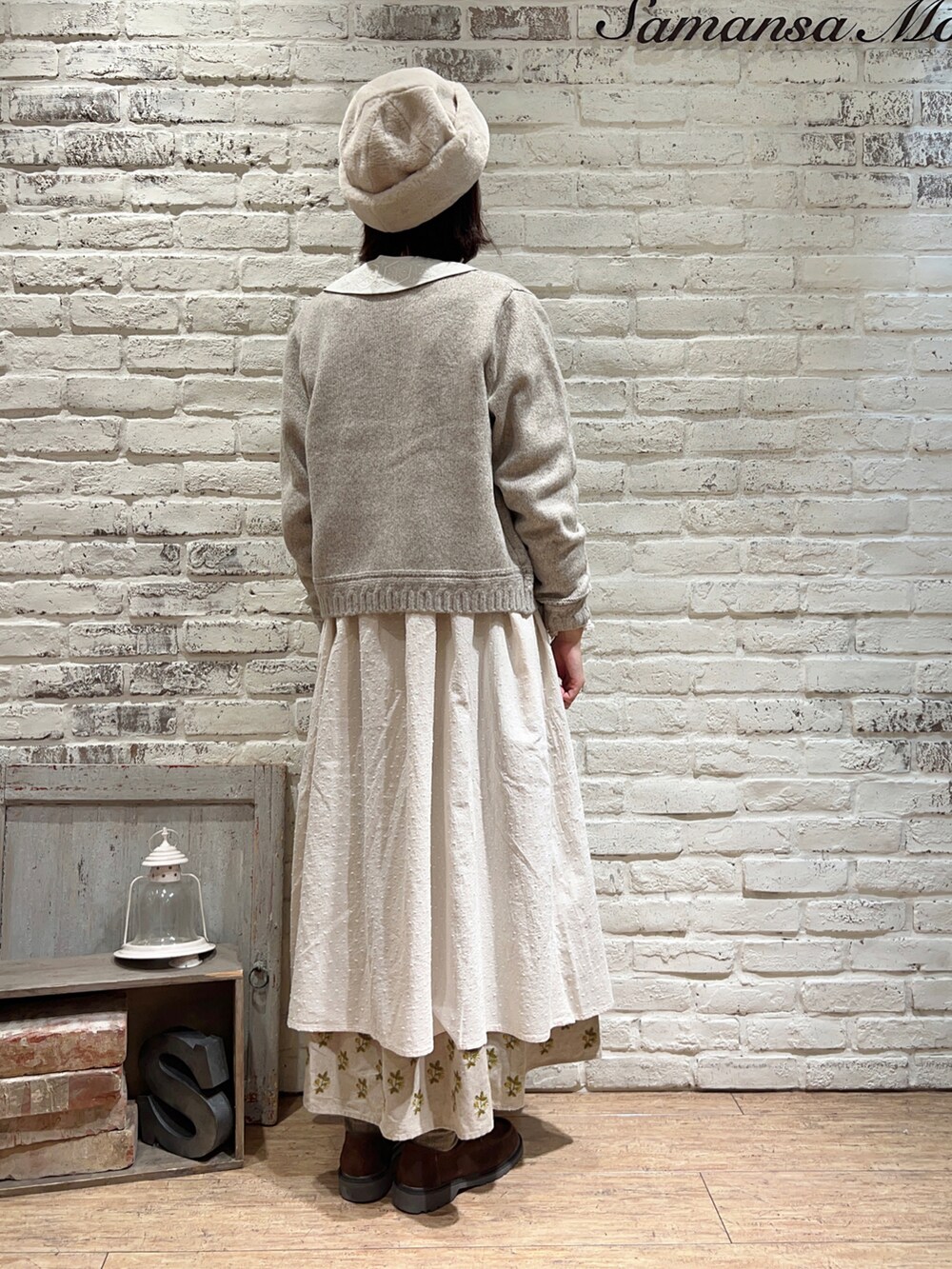 ベージュ系のカーディガン/ボレロ、ホワイト系のワンピース、ブラウン系のハンドバッグを着用したレディースの冬コーディネートの4枚目の写真