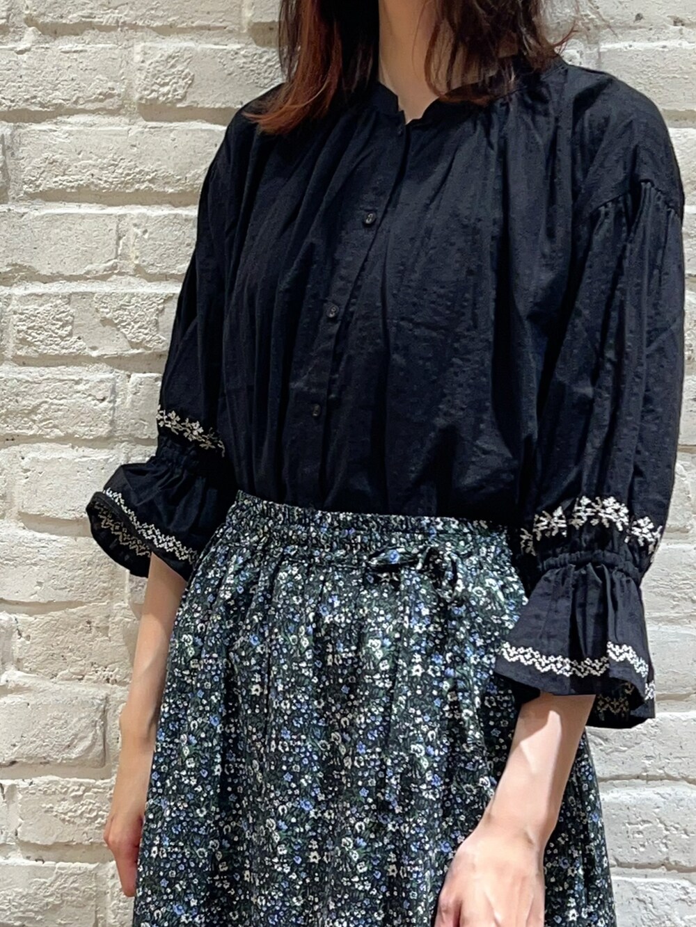 ベージュ系のベスト、ブラック系のシャツ/ブラウス、ブラック系のスカートを着用したレディースの秋コーディネートの3枚目の写真