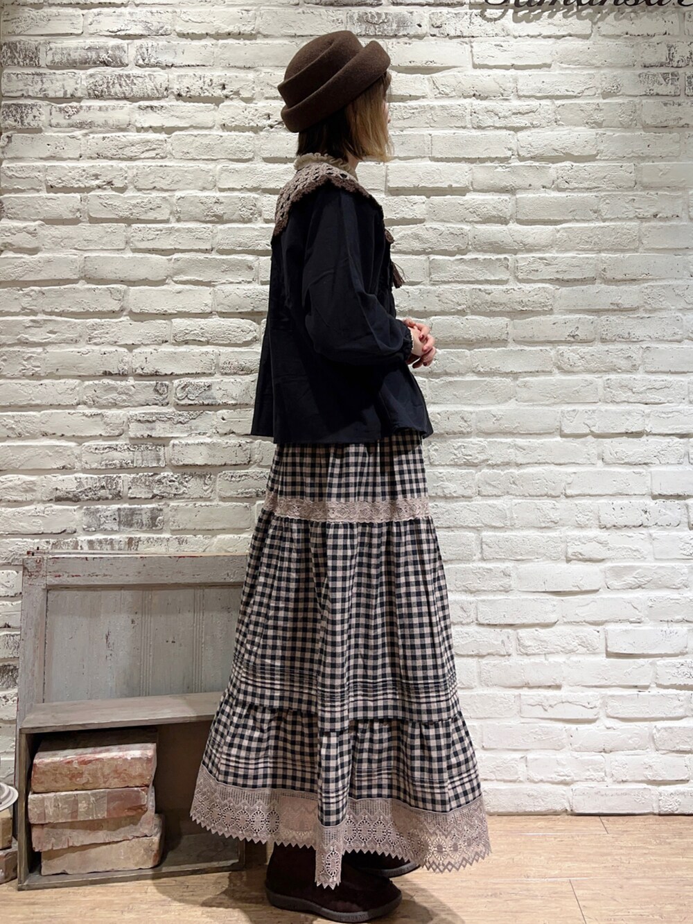 ホワイト系のニット/セーター、ブラック系のシャツ/ブラウス、ブラウン系のハンドバッグを着用したレディースの秋コーディネートの3枚目の写真