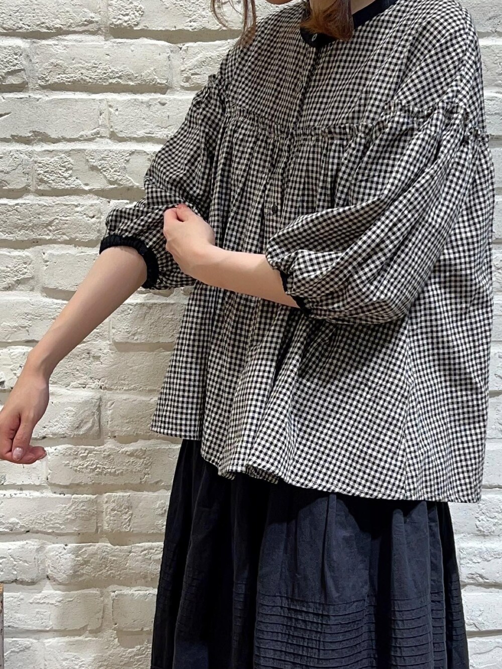 ブラック系のシャツ/ブラウス、ブラック系のスカート、ブラック系のサンダルを着用したレディースの夏コーディネートの2枚目の写真