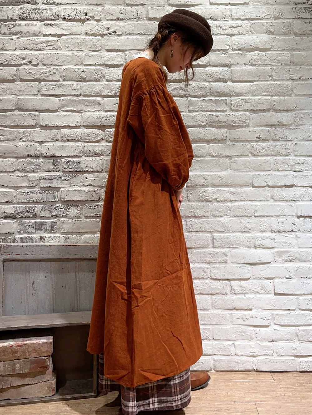 ホワイト系のTシャツ/カットソー、オレンジ系のワンピース、ブラウン系のその他パンツを着用したレディースの秋コーディネートの3枚目の写真