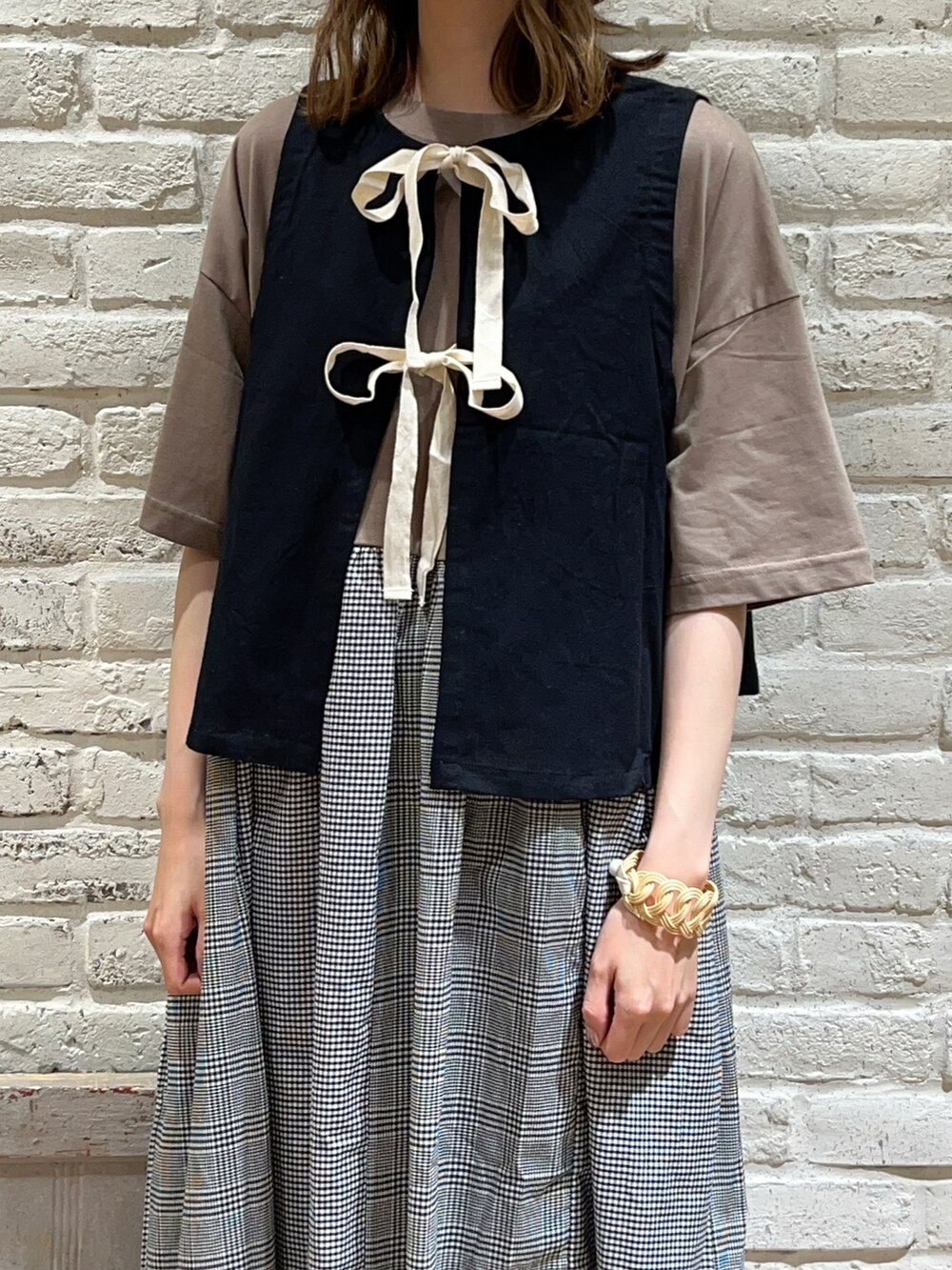 ブラック系のベスト、ブラウン系のワンピース、ブラック系のハットを着用したレディースの秋コーディネートの2枚目の写真