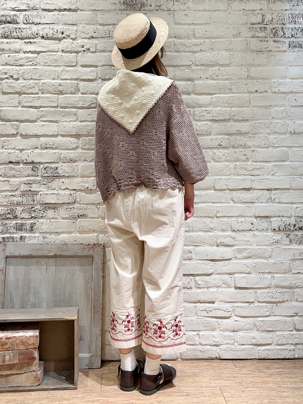 ベージュ系のタンクトップ、ブラウン系のカーディガン/ボレロ、ブラック系のハンドバッグを着用したレディースの春コーディネートの4枚目の写真