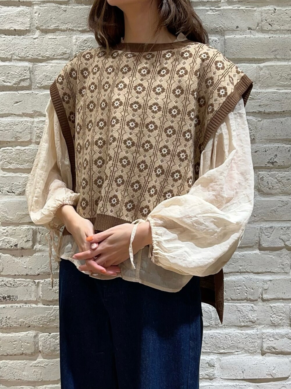 ブラウン系のベスト、ホワイト系のシャツ/ブラウス、ブルー系のデニムパンツを着用したレディースの秋コーディネートの2枚目の写真