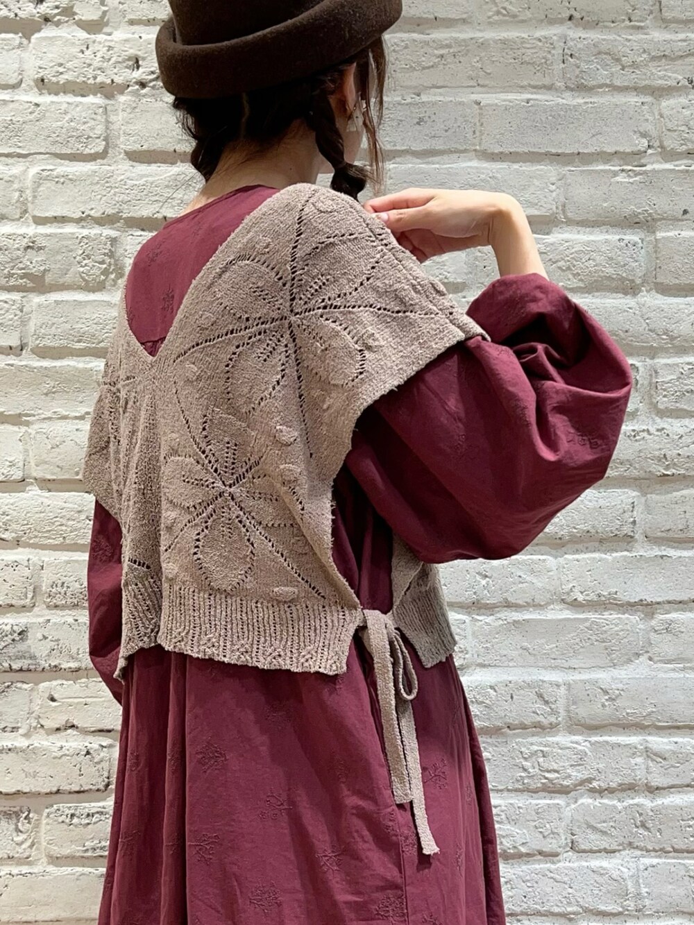 ベージュ系のベスト、レッド系のワンピース、グレー系のその他パンツを着用したレディースの秋コーディネートの3枚目の写真