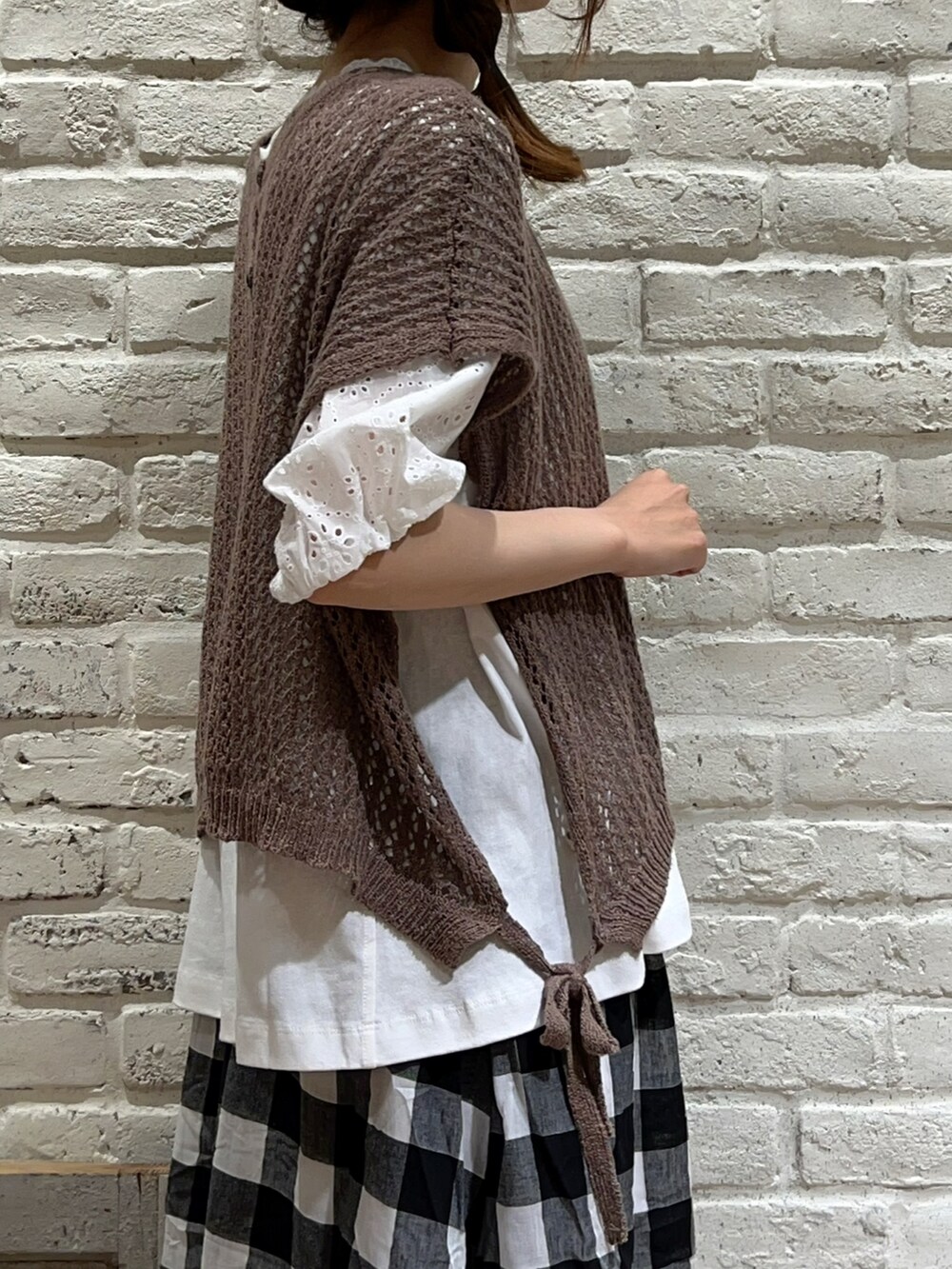 ホワイト系のTシャツ/カットソー、ブラウン系のベスト、ホワイト系のニット/セーターを着用したレディースの夏コーディネートの3枚目の写真
