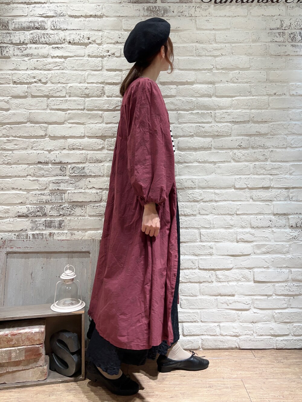 ホワイト系のTシャツ/カットソー、レッド系のワンピース、ブラック系のスカートを着用したレディースの秋コーディネートの3枚目の写真