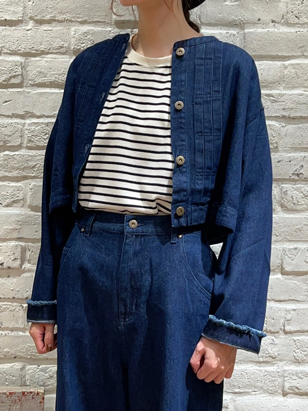 ホワイト系のTシャツ/カットソー、ブルー系のブルゾン、ブルー系のデニムパンツを着用したレディースの秋コーディネートの2枚目の写真