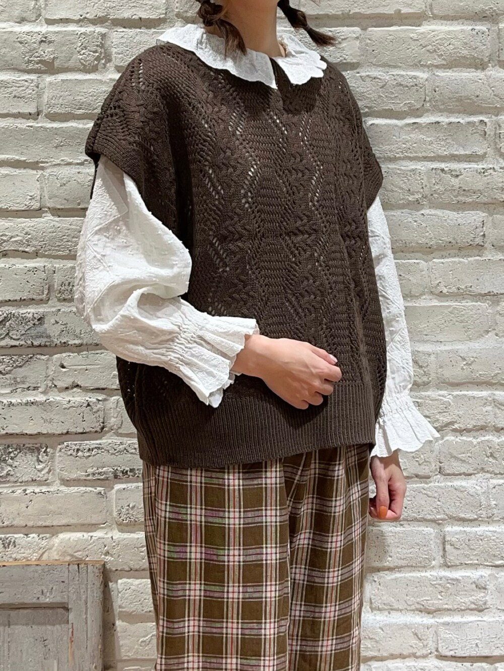 ホワイト系のシャツ/ブラウス、ブラウン系のベスト、ブラウン系のハンドバッグを着用したレディースの秋コーディネートの2枚目の写真