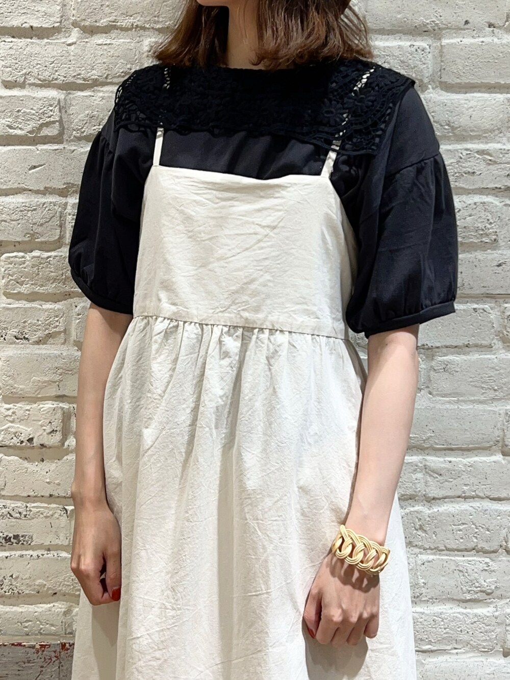 グレー系のTシャツ/カットソー、ブラック系のハンドバッグ、ホワイト系のワンピースを着用したレディースの秋コーディネートの2枚目の写真