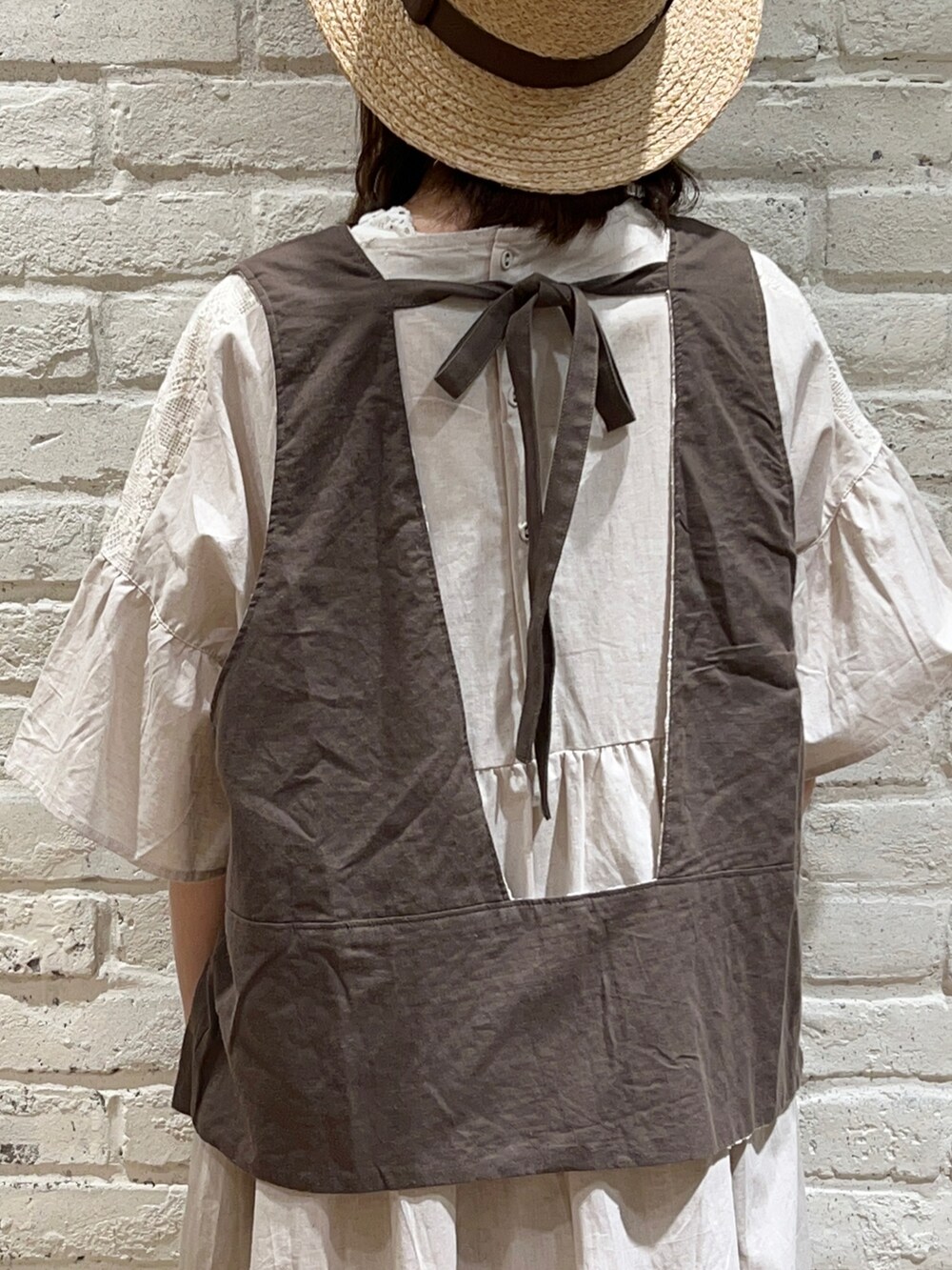 ホワイト系のタンクトップ、ホワイト系のベスト、ホワイト系のワンピースを着用したレディースの春コーディネートの4枚目の写真