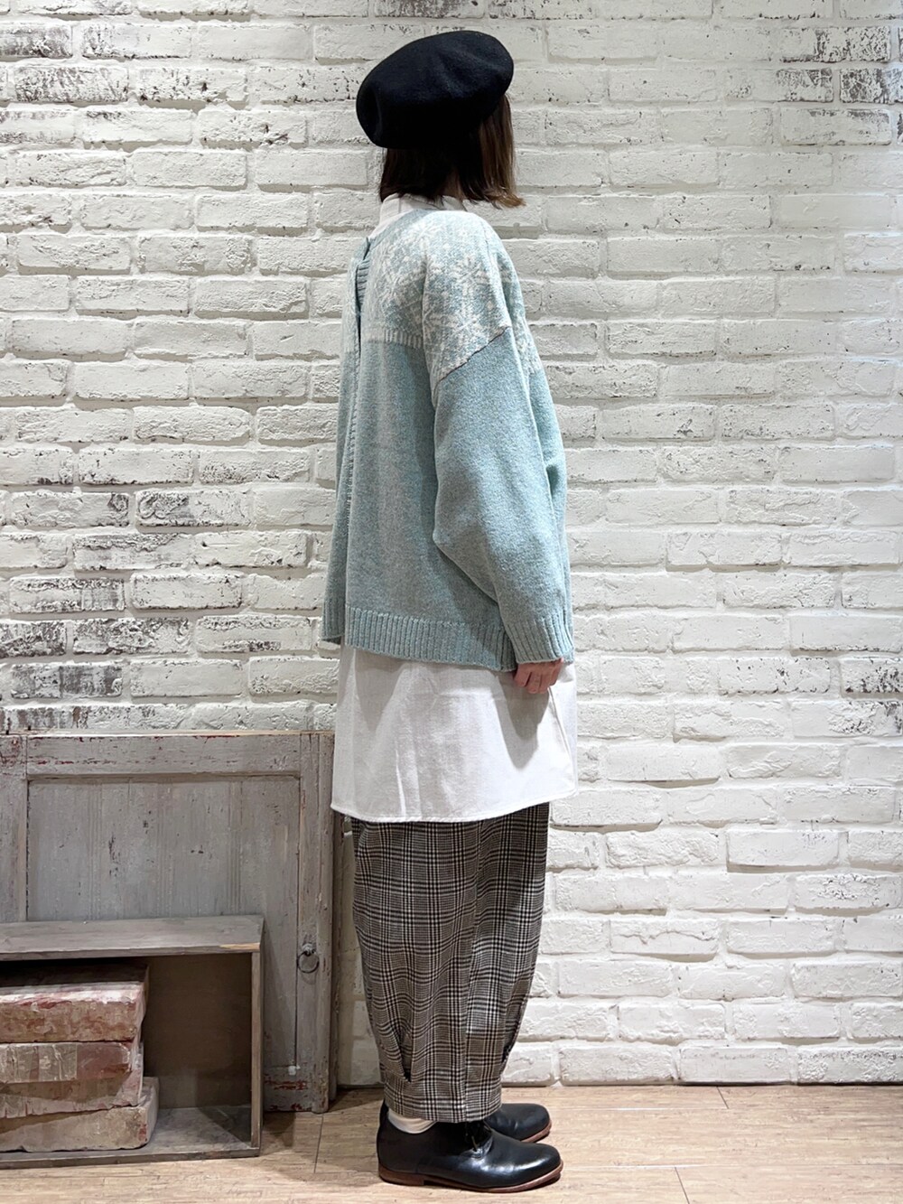 ホワイト系のニット/セーター、グリーン系のカーディガン/ボレロ、グレー系のチュニックを着用したレディースの冬コーディネートの3枚目の写真