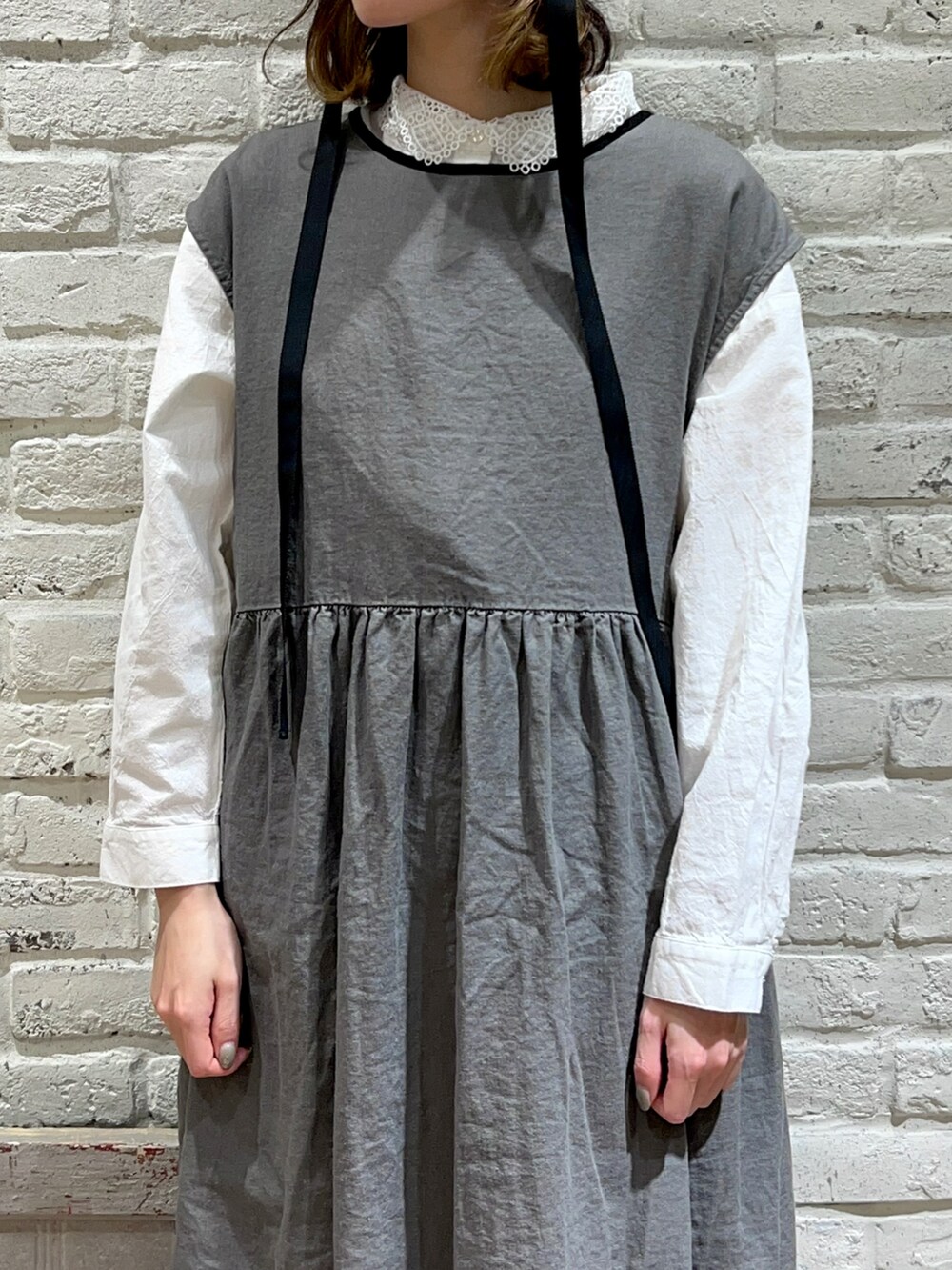 ホワイト系のシャツ/ブラウス、ベージュ系のカーディガン/ボレロ、グレー系のワンピースを着用したレディースの春コーディネートの2枚目の写真