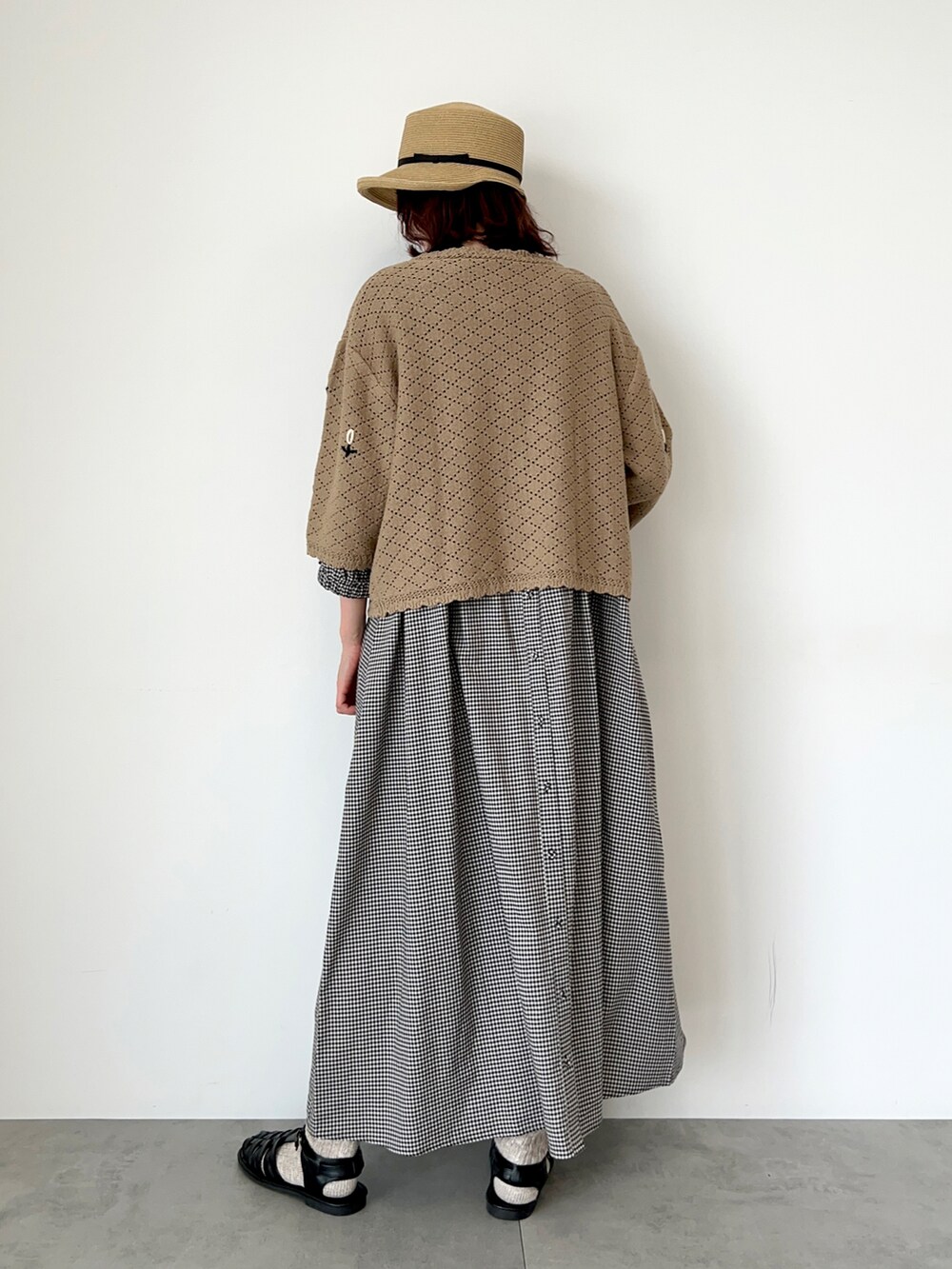 ベージュ系のカーディガン/ボレロ、ベージュ系のワンピース、ブラック系のサンダルを着用したレディースの春コーディネートの4枚目の写真