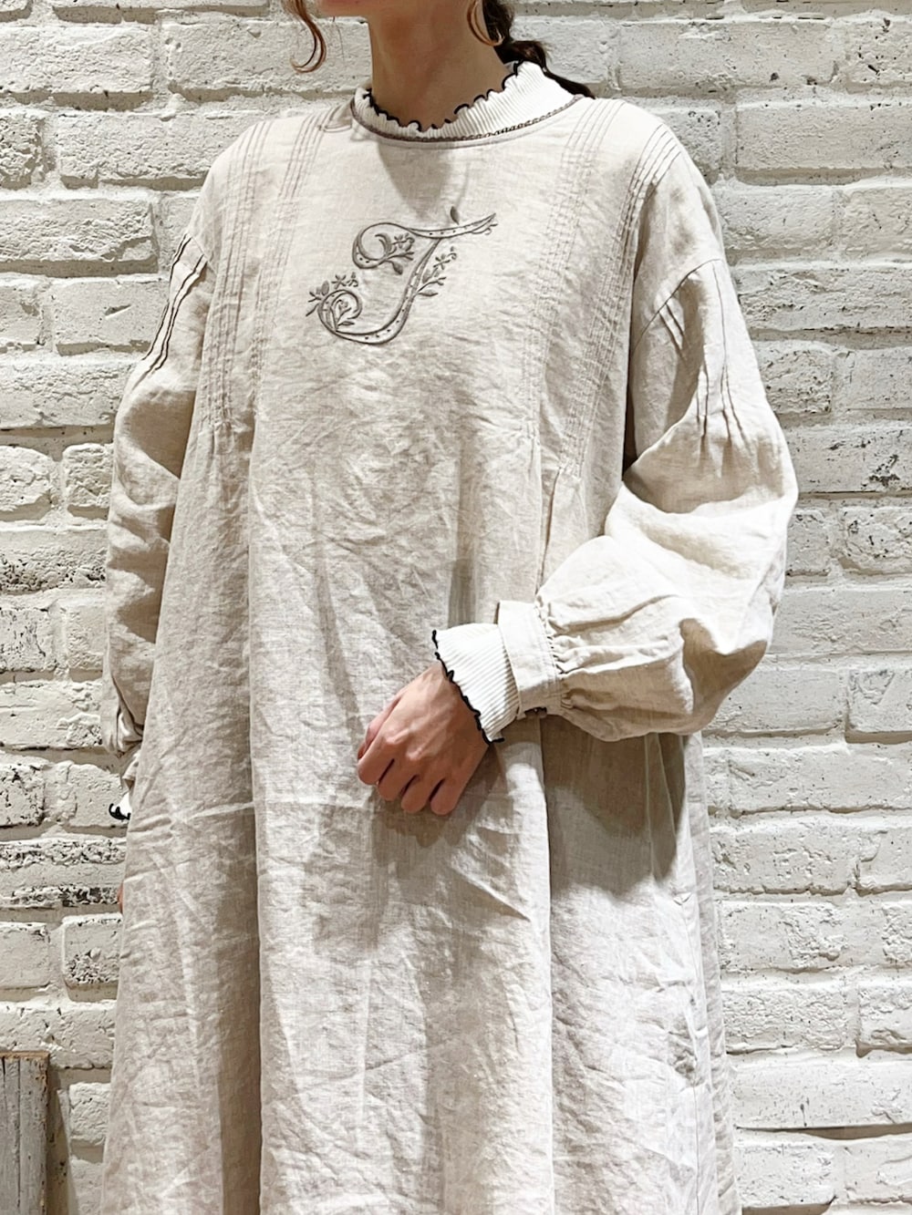 ホワイト系のTシャツ/カットソー、ベージュ系のベスト、ベージュ系のワンピースを着用したレディースの冬コーディネートの3枚目の写真