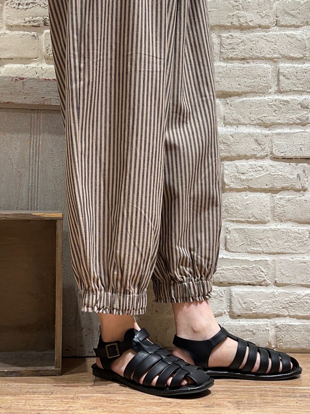 オレンジ系のTシャツ/カットソー、ホワイト系のハンドバッグ、ベージュ系のその他パンツを着用したレディースの秋コーディネートの5枚目の写真