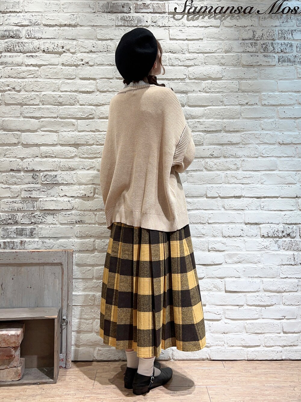 ホワイト系のTシャツ/カットソー、ブラウン系のポンチョ、ホワイト系のニット/セーターを着用したレディースの秋コーディネートの5枚目の写真