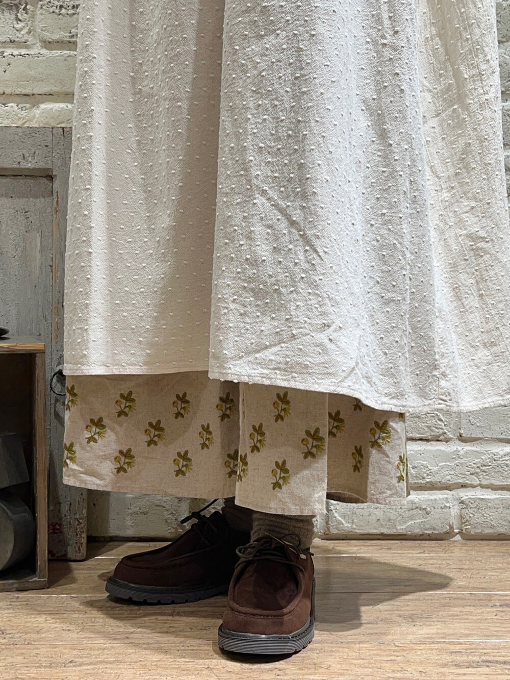 ベージュ系のカーディガン/ボレロ、ホワイト系のワンピース、ブラウン系のハンドバッグを着用したレディースの冬コーディネートの5枚目の写真